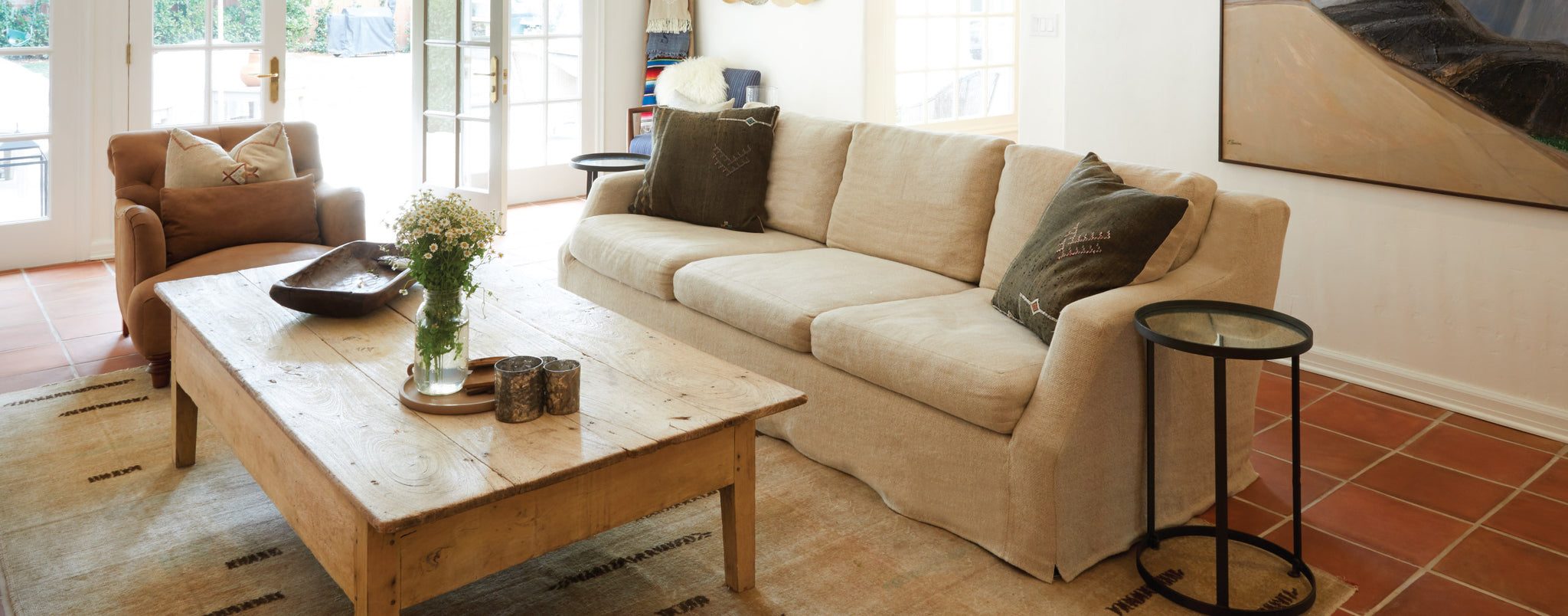 Interior shot of a light brown sofa with matching chair and a wooden coffee table in the center
