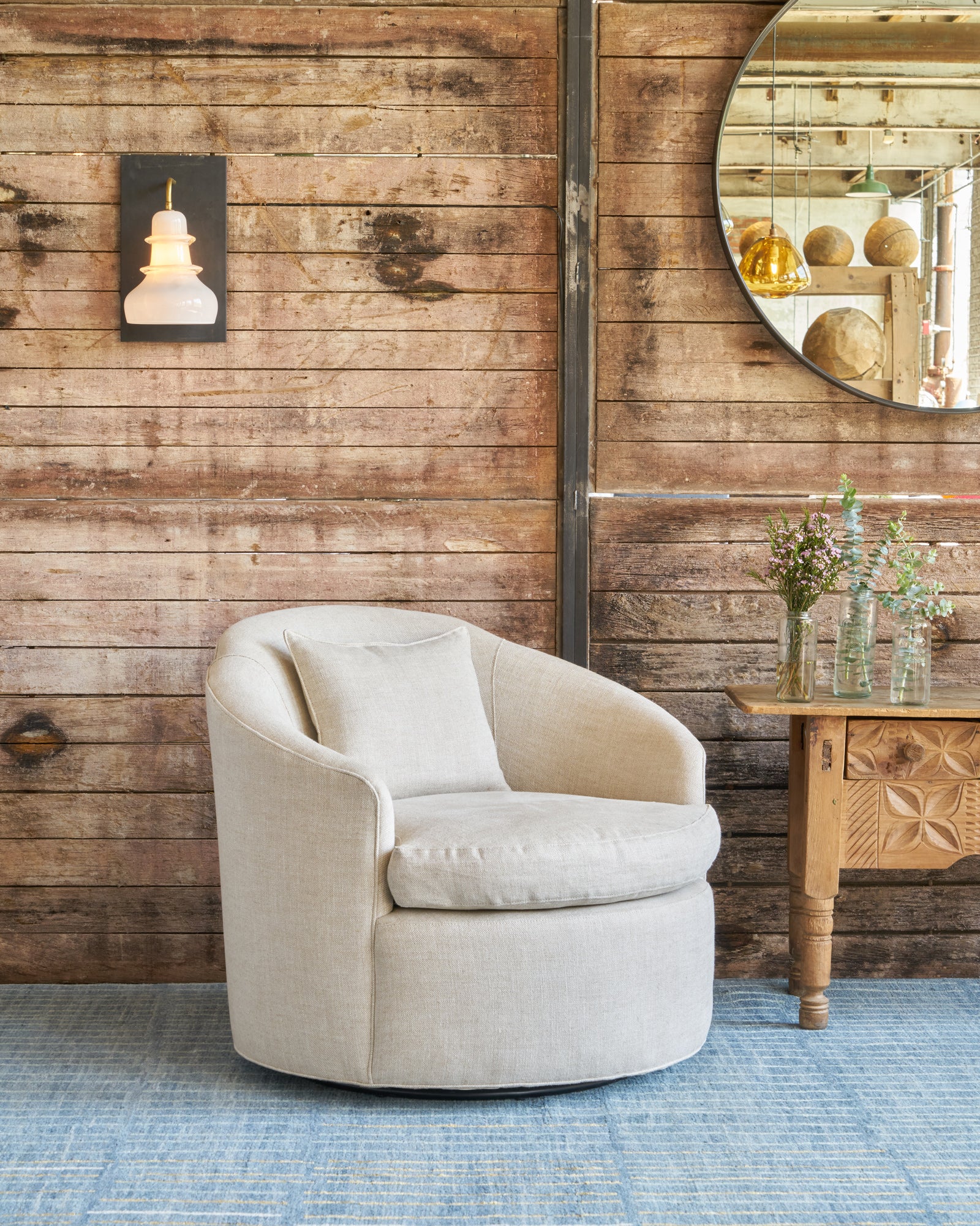  Chair in front of a wood wall with a white wall sconce. Photographed in Avery Oatmeal. 