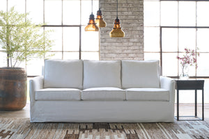  White sofa in a showroom with 3 glass light pendants. Photographed in Ashville White. 
