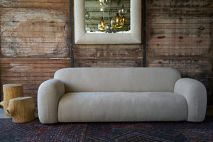  Sofa with large arms in front of a wood wall with a mirror. Photographed in Brevard Burlap. 