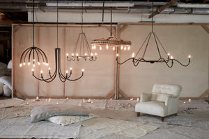  Array of chandelier's hanging above bed toppers and an Acacia chair.  