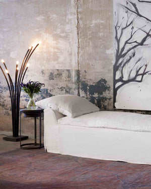  Ramo floor lamp next to slip covered daybed in white fabric.  