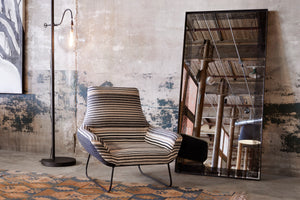  Stripped chair next to a floor mirror and a floor lamp with a round glass pendant. Photographed in Rayas Fino. 