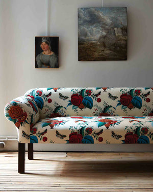  Detail of the Teddy sofa in a John Derian floral fabric in a white room with 2 painting on the wall. Photographed in John Derian fabric. 