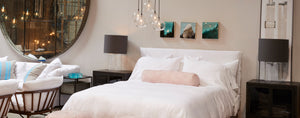 interior shot of a white Cisco bed with side tables and glass cylinder table lamps