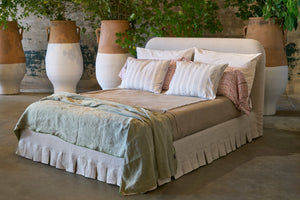  Bed in a showroom in front of terracotta pots with white paint. Photographed in Devon Oatmeal. 