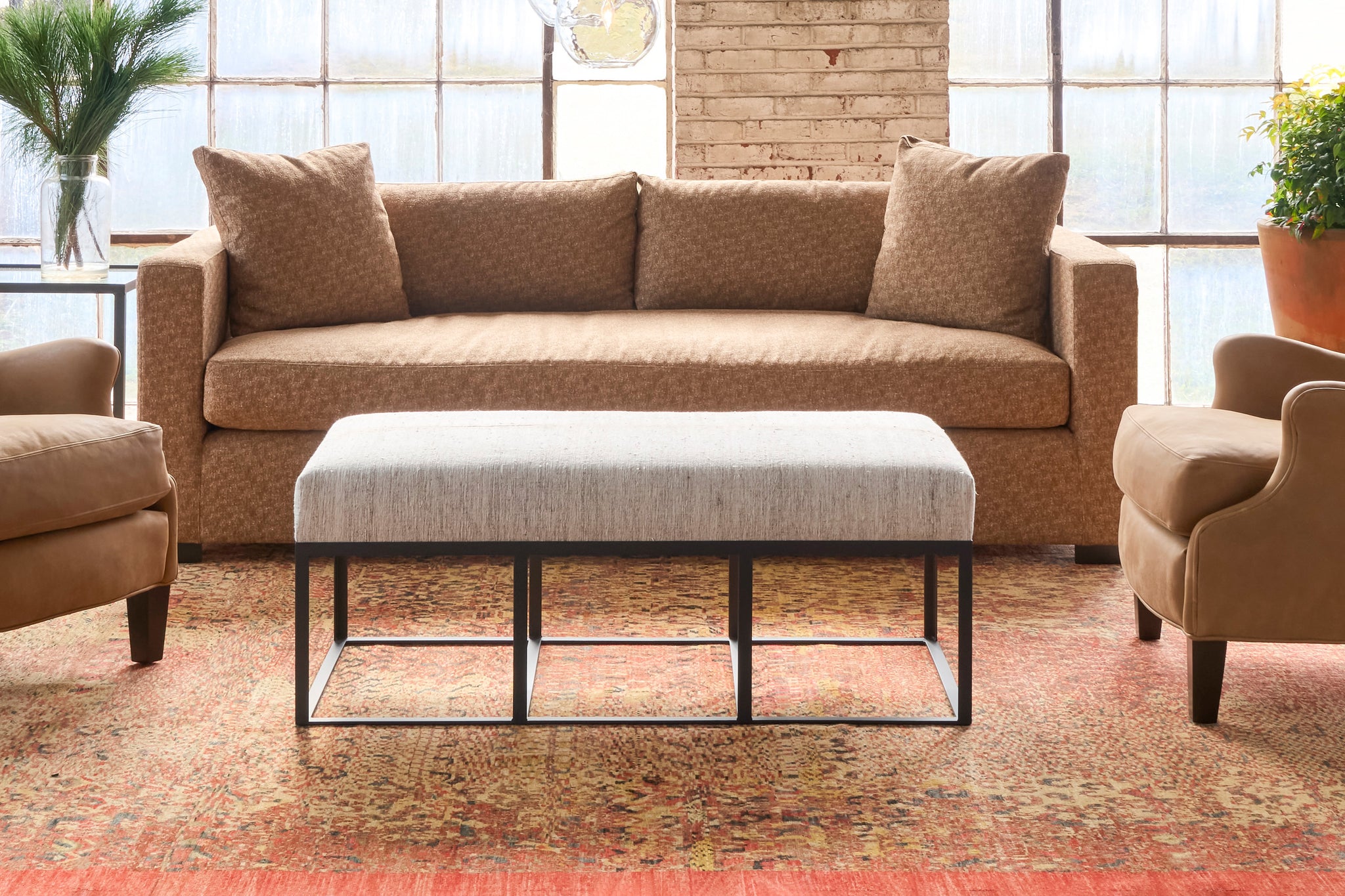  Ottoman in front of a brown sofa. Photographed in One Of a Kind Hemp. 