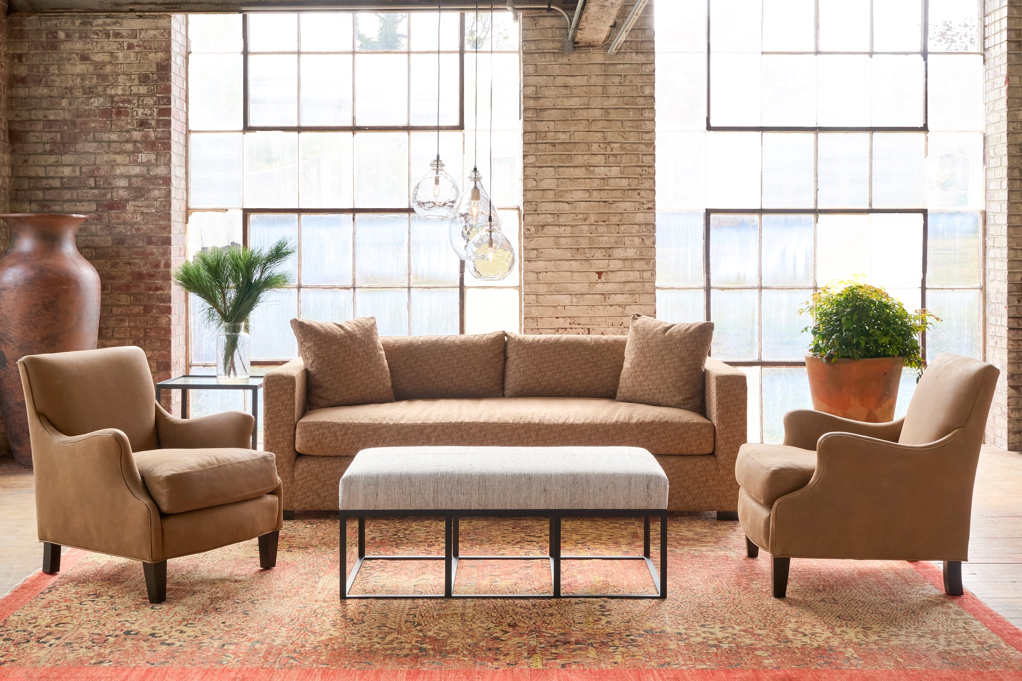  Ottoman in front of a brown sofa with 2 leather chairs. Photographed in One Of a Kind Hemp. 