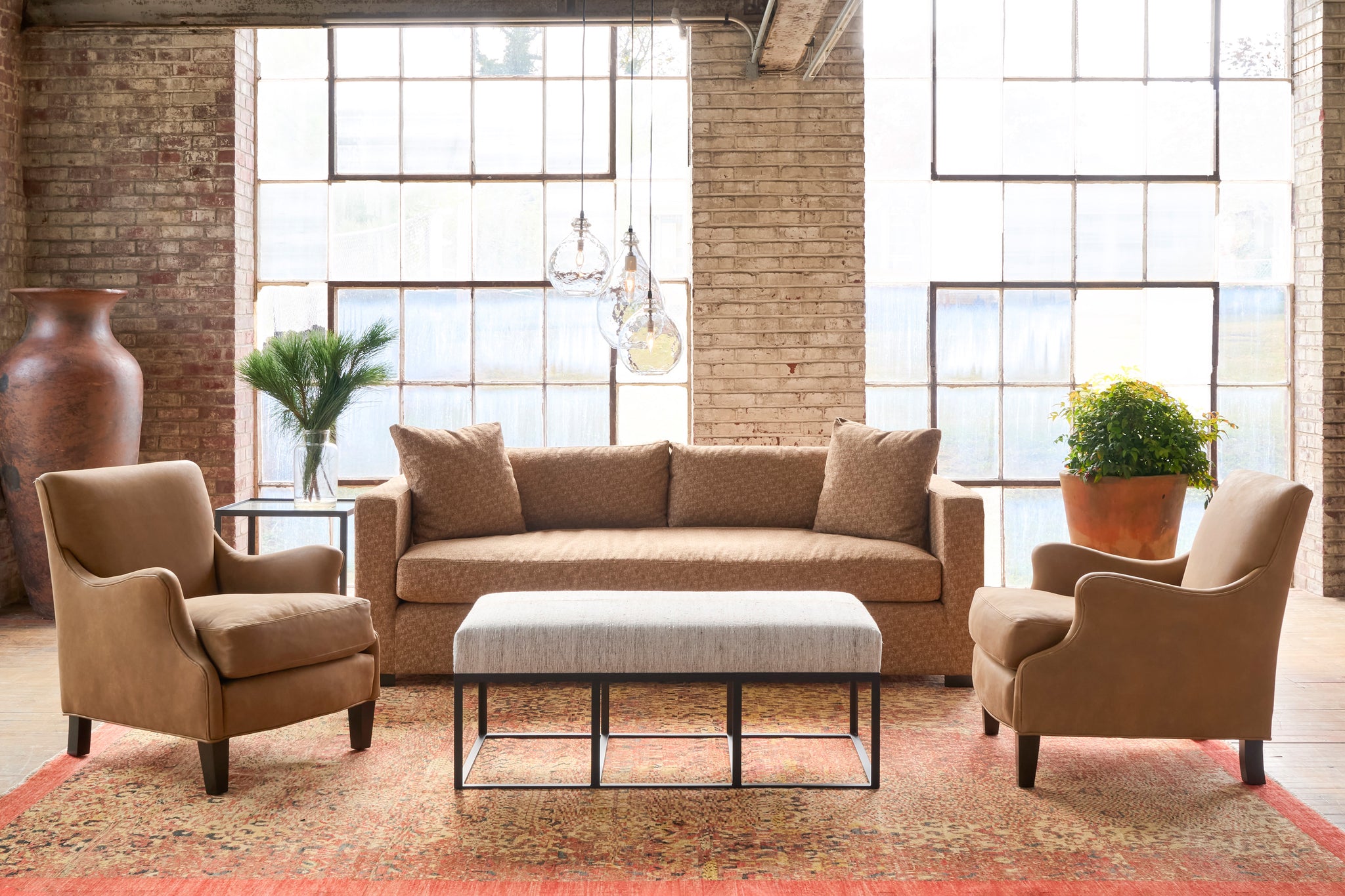  Brown sofa with brown chairs on an orange rug. Photographed in Marvell Latte. 