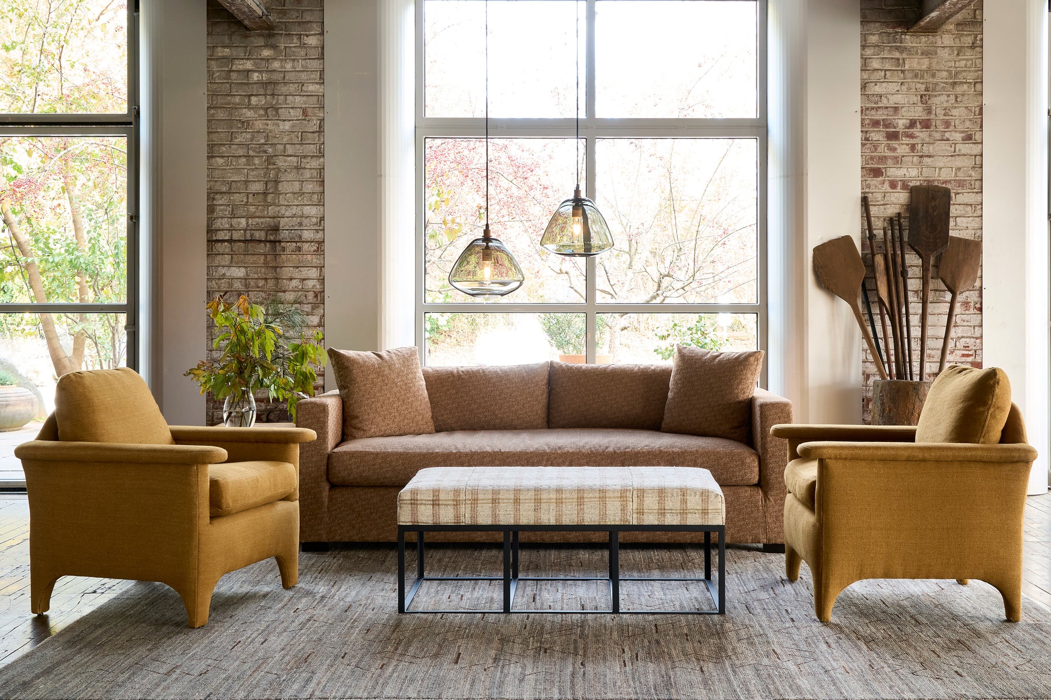  Living room with brown sofa, yellow armchairs, and decorative elements. Photographed in Lucerne Hazelnut. 