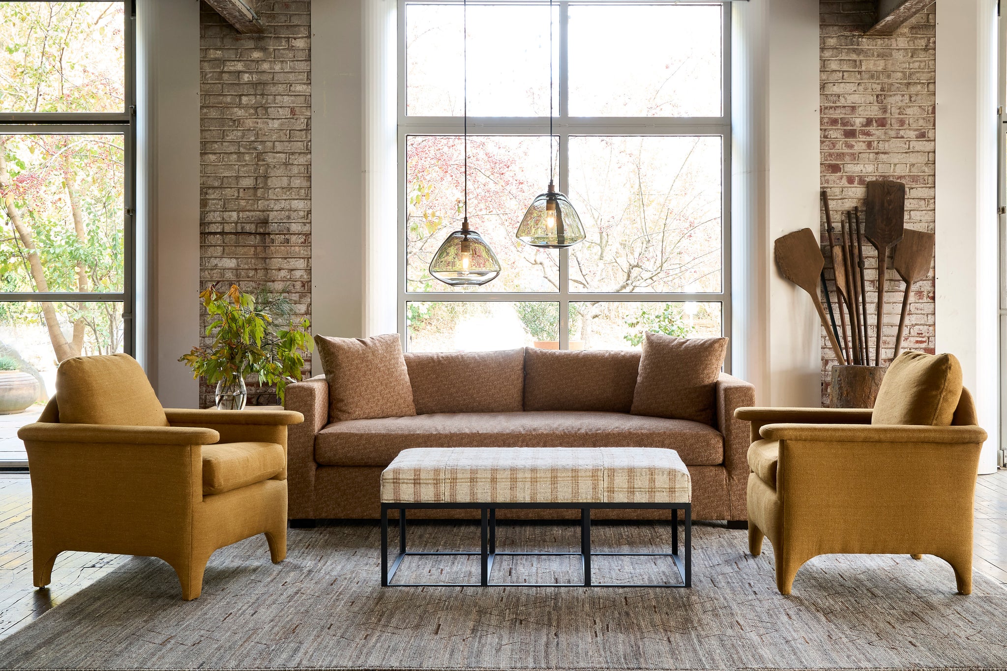  Ottoman in front of a brown sofa with 2 yellow chairs. Photographed in One Of a Kind Hemp. 