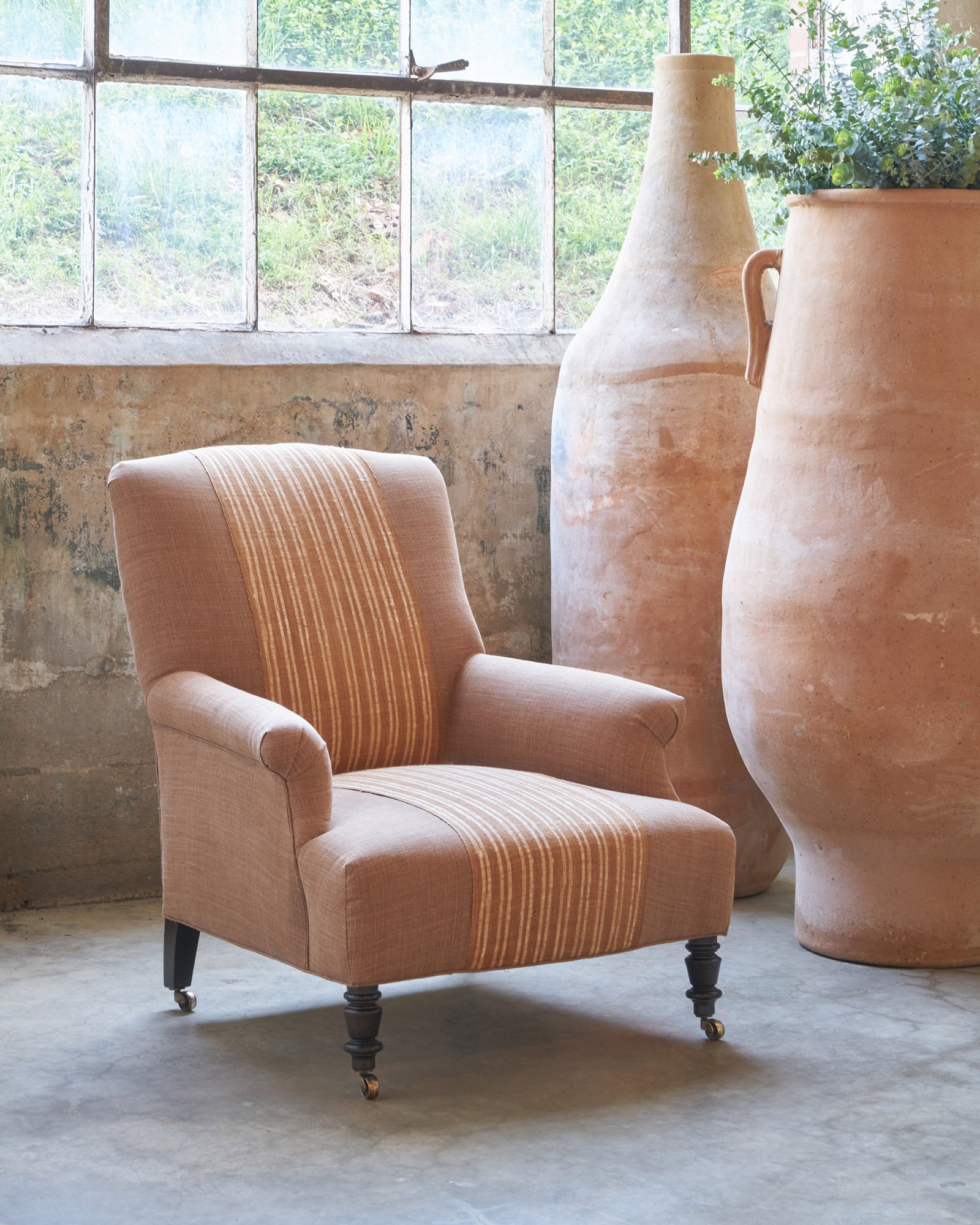  Brown chair next to large terracotta pots. Photographed in Rye Spice. 