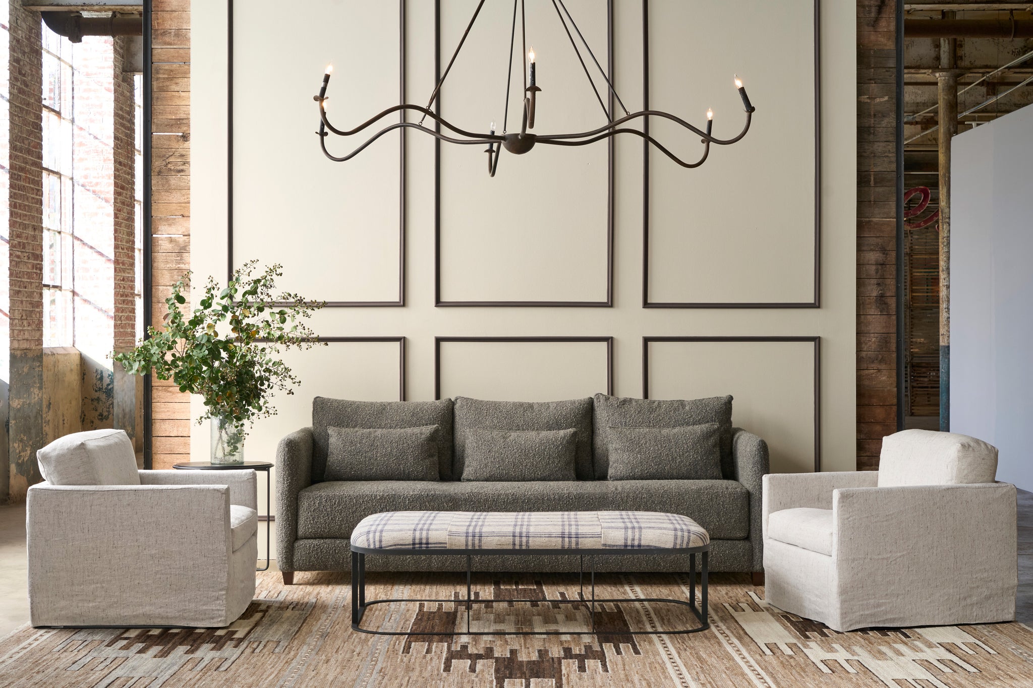  Living room with gray sofa, armchairs, and a chandelier. Photographed in Andrews Natural. 