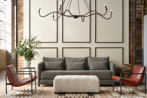  Modern living room with gray sofa, red chairs, and decorative elements. Photographed in Foret Ivory 