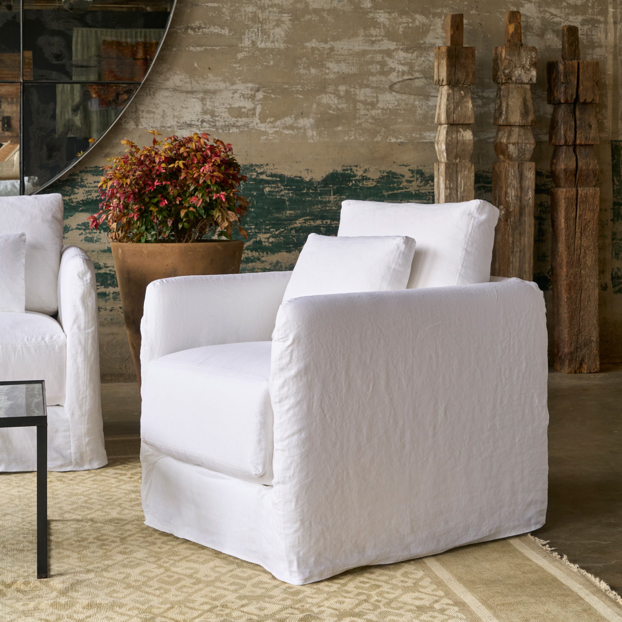  Chair in front of a wall with 3 wood columns and a pot with a plant. Photographed in Otis White. 
