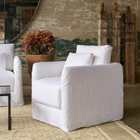 Chair in front of a wall with 3 wood columns and a pot with a plant. Photographed in Otis White.