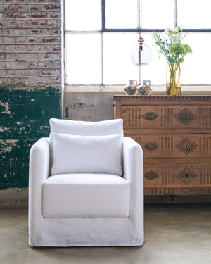  Chair in front of a window and set of drawers and flowers  on top. Photographed in Otis White. 