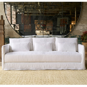  White sofa in front of an oversized mirror. Photographed in Otis White. 
