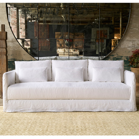 White sofa in front of an oversized mirror. Photographed in Otis White.