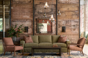  Living room with green sofa, brown armchairs, and wooden wall. Photographed in Knobby Canyon. 