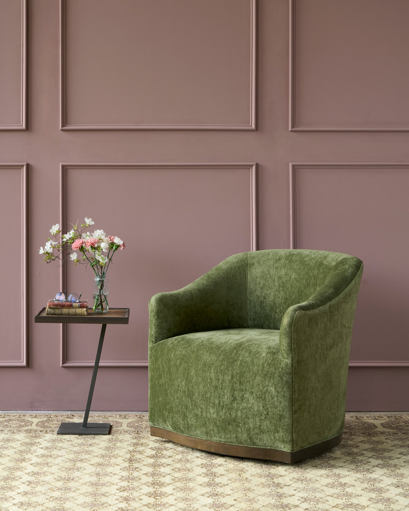  Green chair in front of a purple wall. Side table on the left with flowers. Photographed in Velluto Olive. 