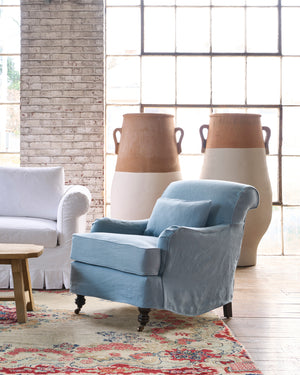  Blue slipcovered chair in front of 2 painted terracotta pots. Photographed in Brevard Ciel. 