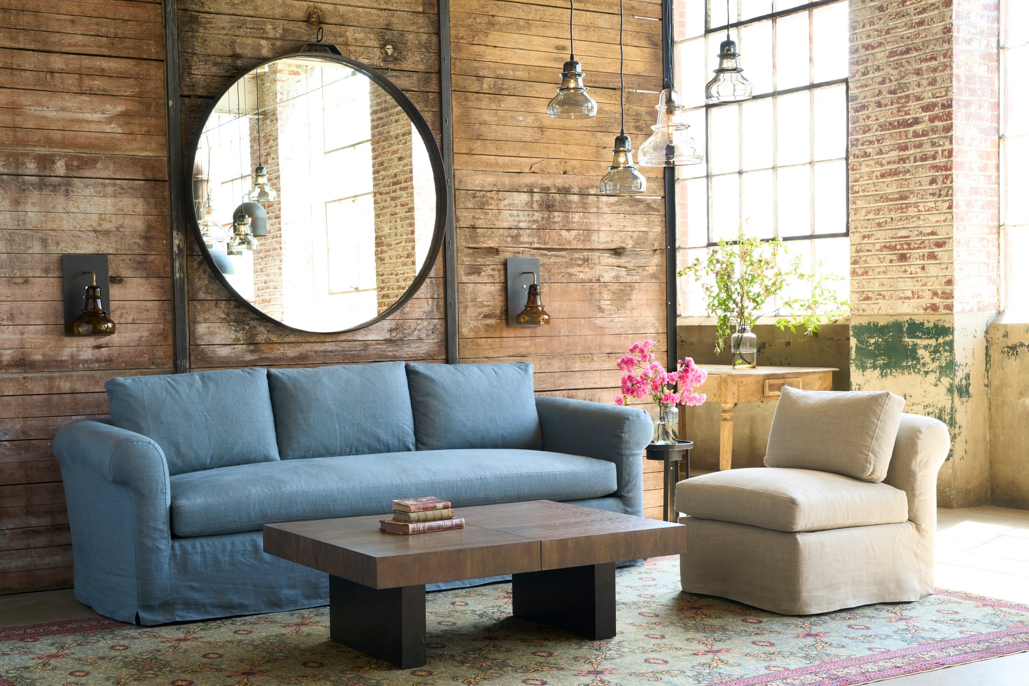  Sofa in blue in front of a wood wall with an oatmeal chair on the right. Photographed in Devon Oatmeal. 
