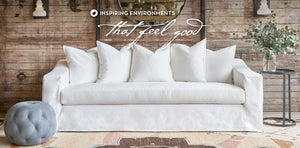 White sofa with light blue ottoman and the words inspiring environments that feel good.