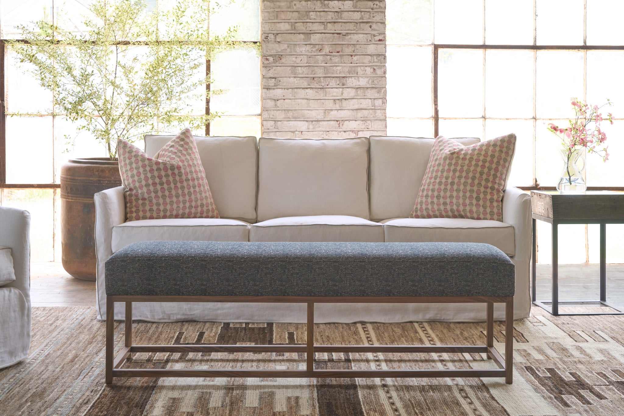  Showroom with white sofa and a black bench with a wood base. Photographed in Adler Pepper. 