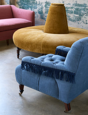  Red sofa, gold velvet round sofa, blue chair with fringes. Photographed in Velluto Gold. 