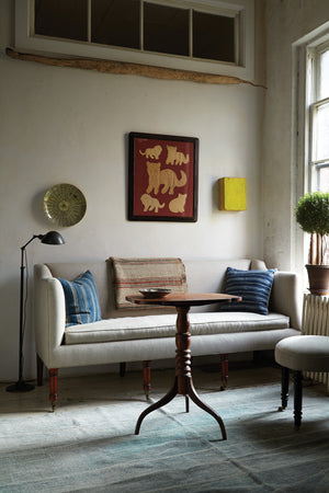  Sofa in a room by a window with a wood table and art on the wall. Photographed in JD Vintage Flax. 