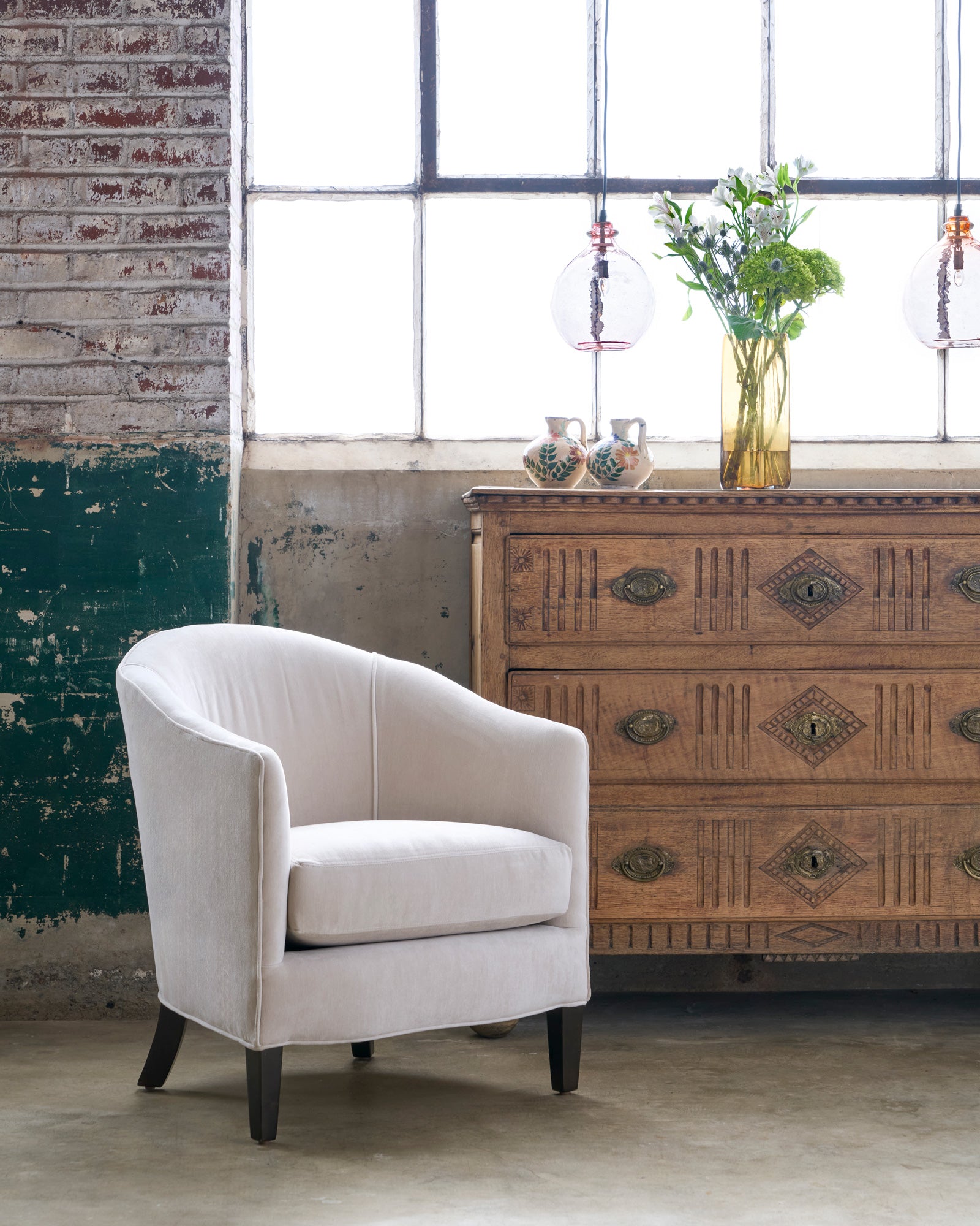  Velvet chair in front of a wooden chest of drawers. Photographed in Apollo Bisque. 