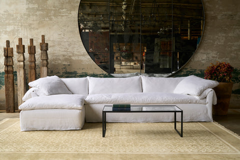 White sectional in front of a large mirror. Photographed in Logan White.