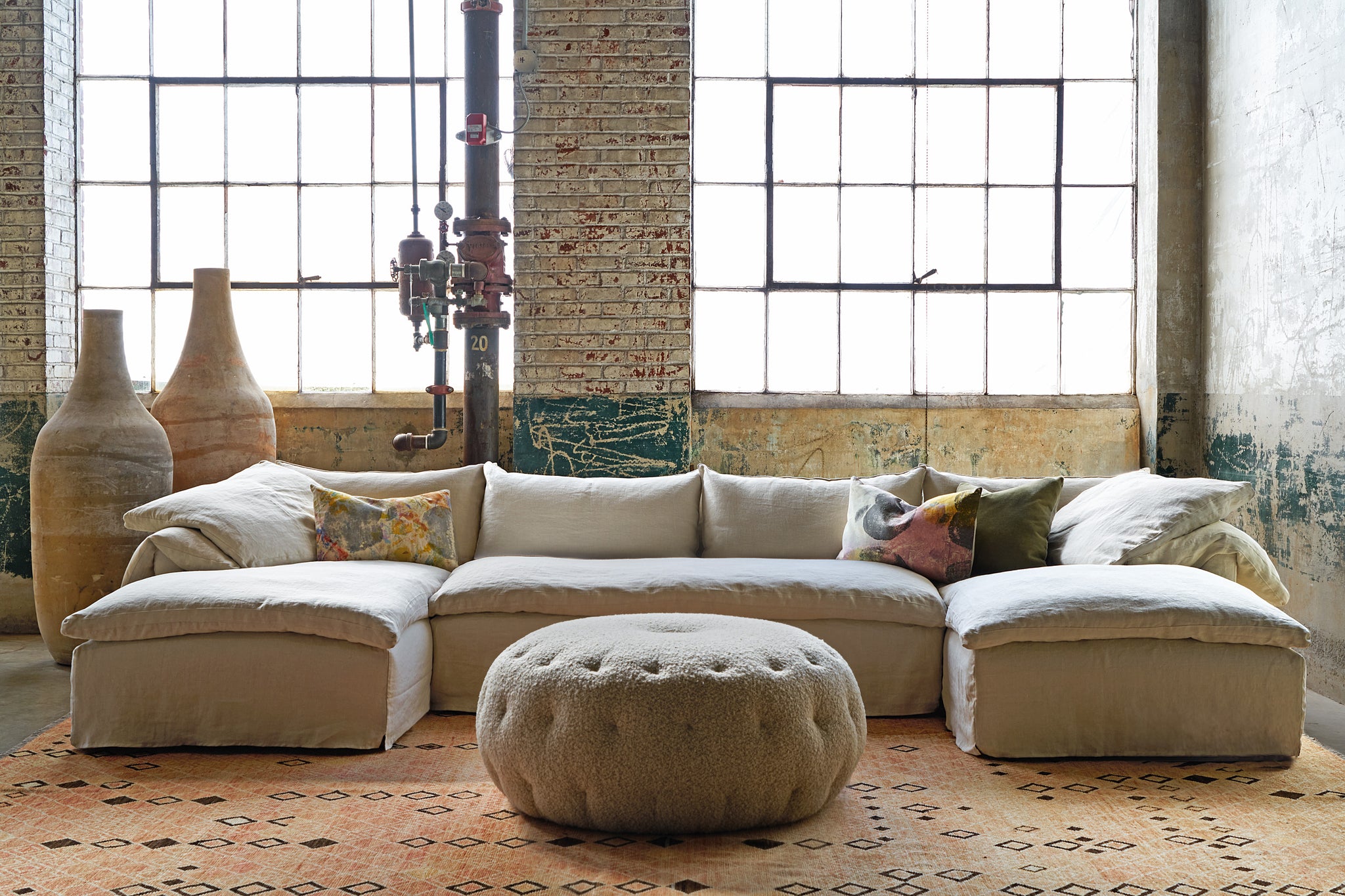  Large 3 piece sectional in front of windows with a pouf in front. Photographed in Knobby Mineral. 
