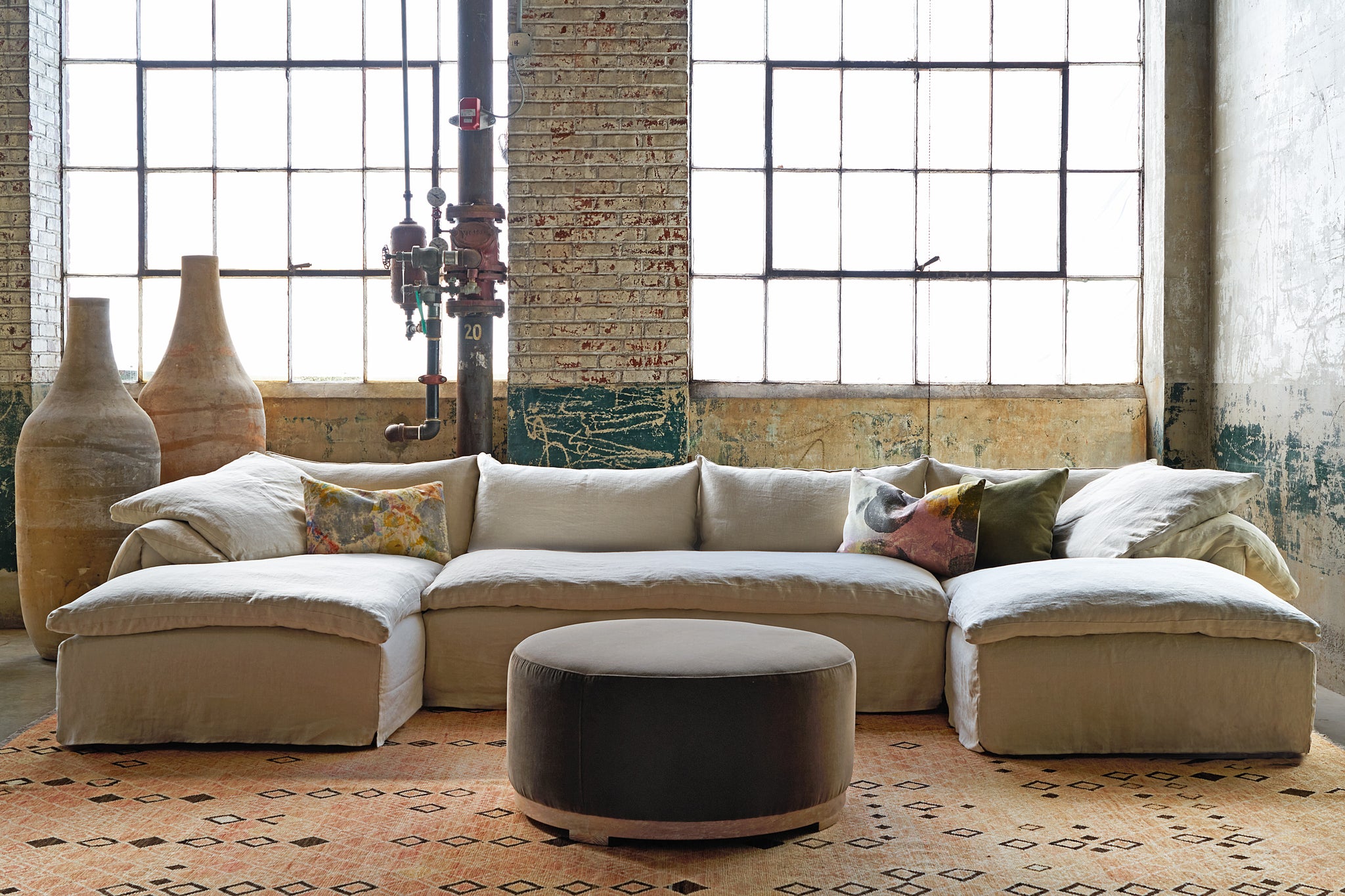  Large 3 piece sectional in front of windows with a pouf in front. Photographed in Lucas Cafe. 