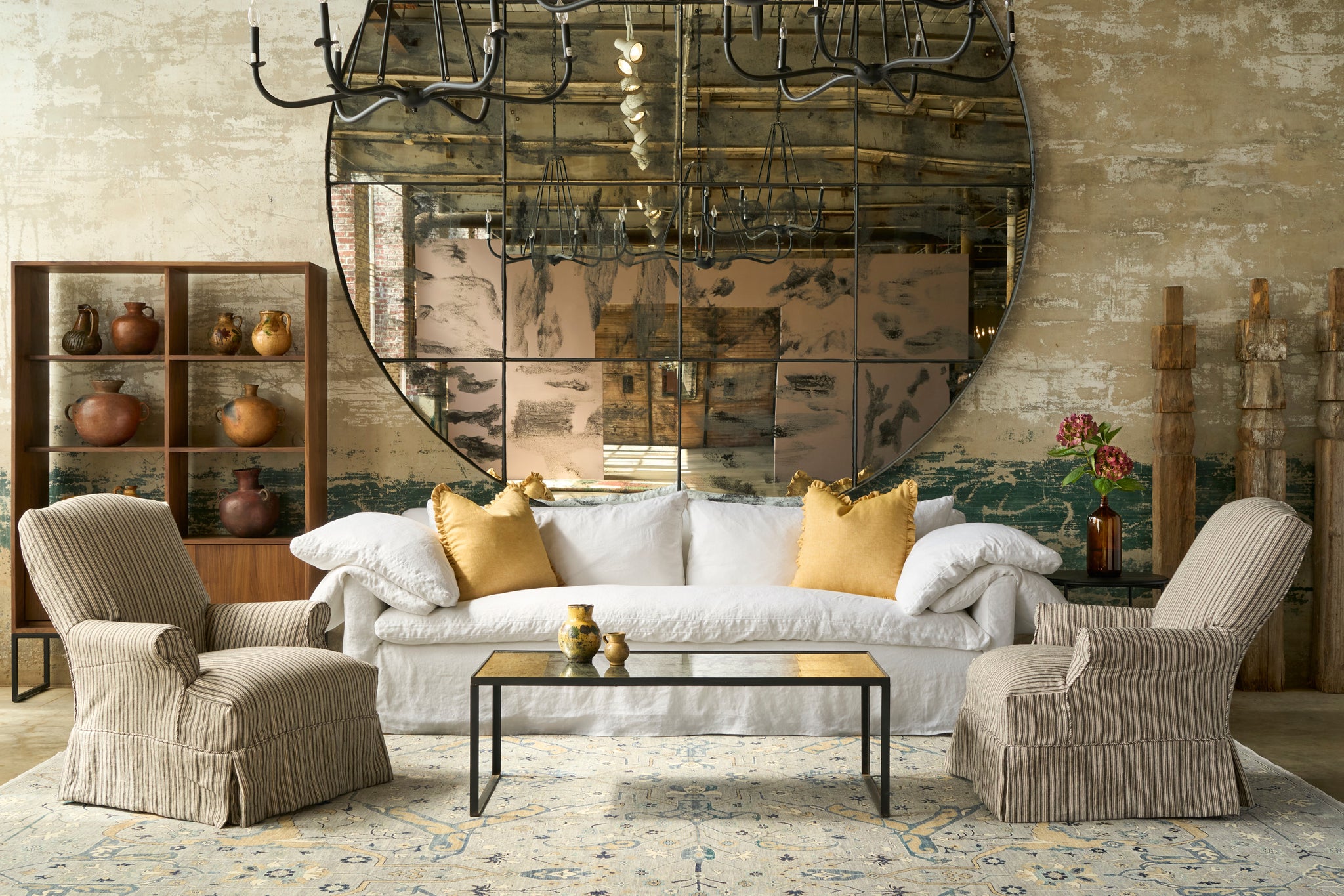  Living room with a large mirror, sofa, and armchairs. Photographed in Hickory Noire. 