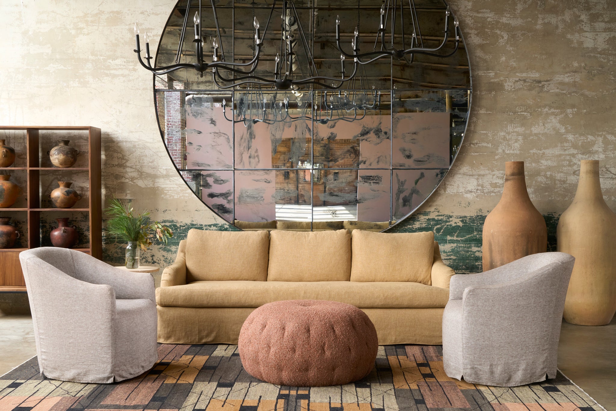  Living room with beige sofa, two chairs, and a round mirror on the wall. Photographed in Knobby Canyon. 