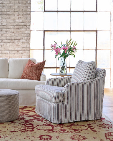 Chair with stripes in a showroom next to a white a white sofa. Photographed in Bridget Chestnut.