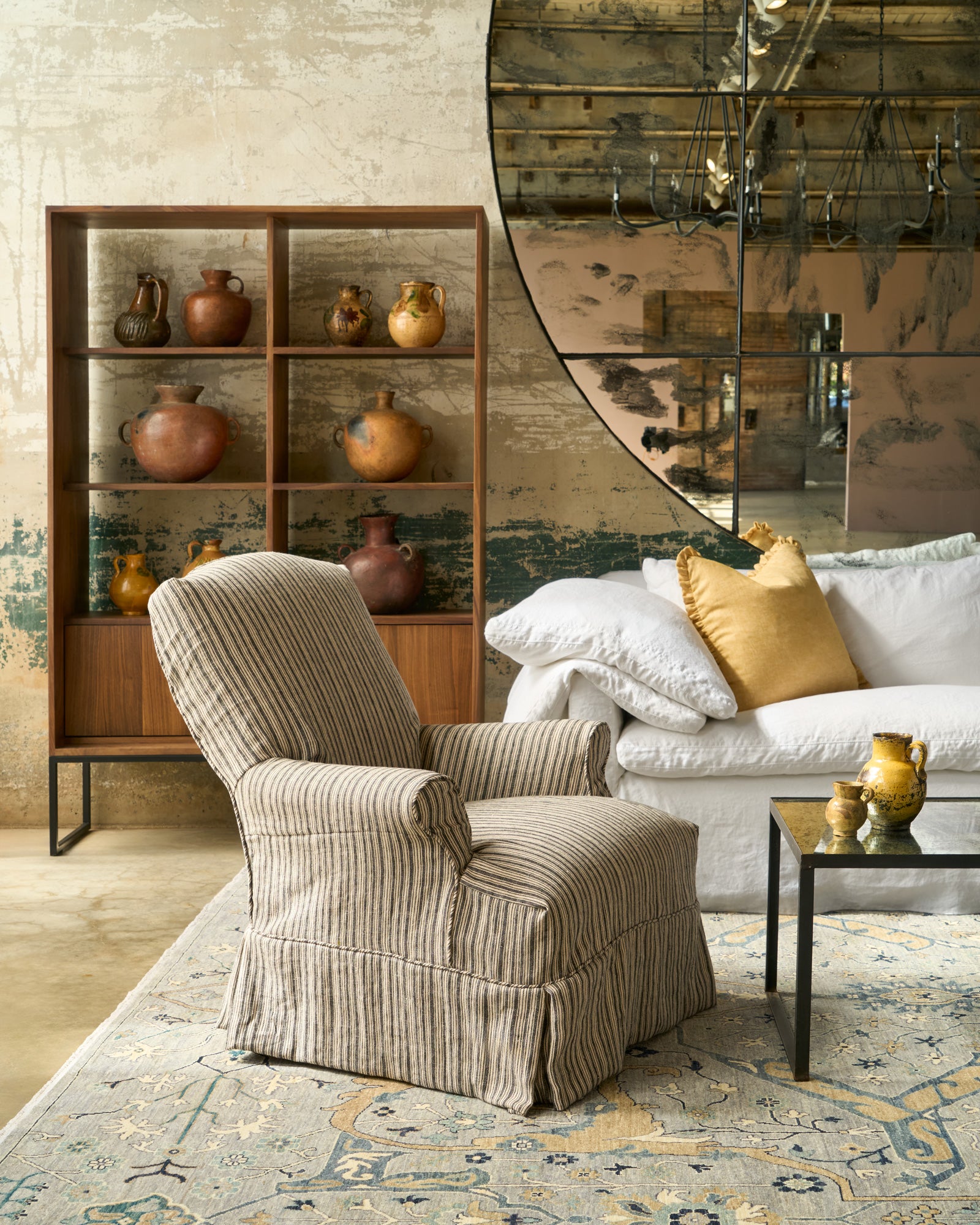  Black and white striped chair in front of a bookcase with pots and a mirror. Photographed in Hickory Noire. 