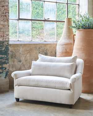  Large chair in front of a window and two tall terracotta pots. Photographed in Noah Bone. 