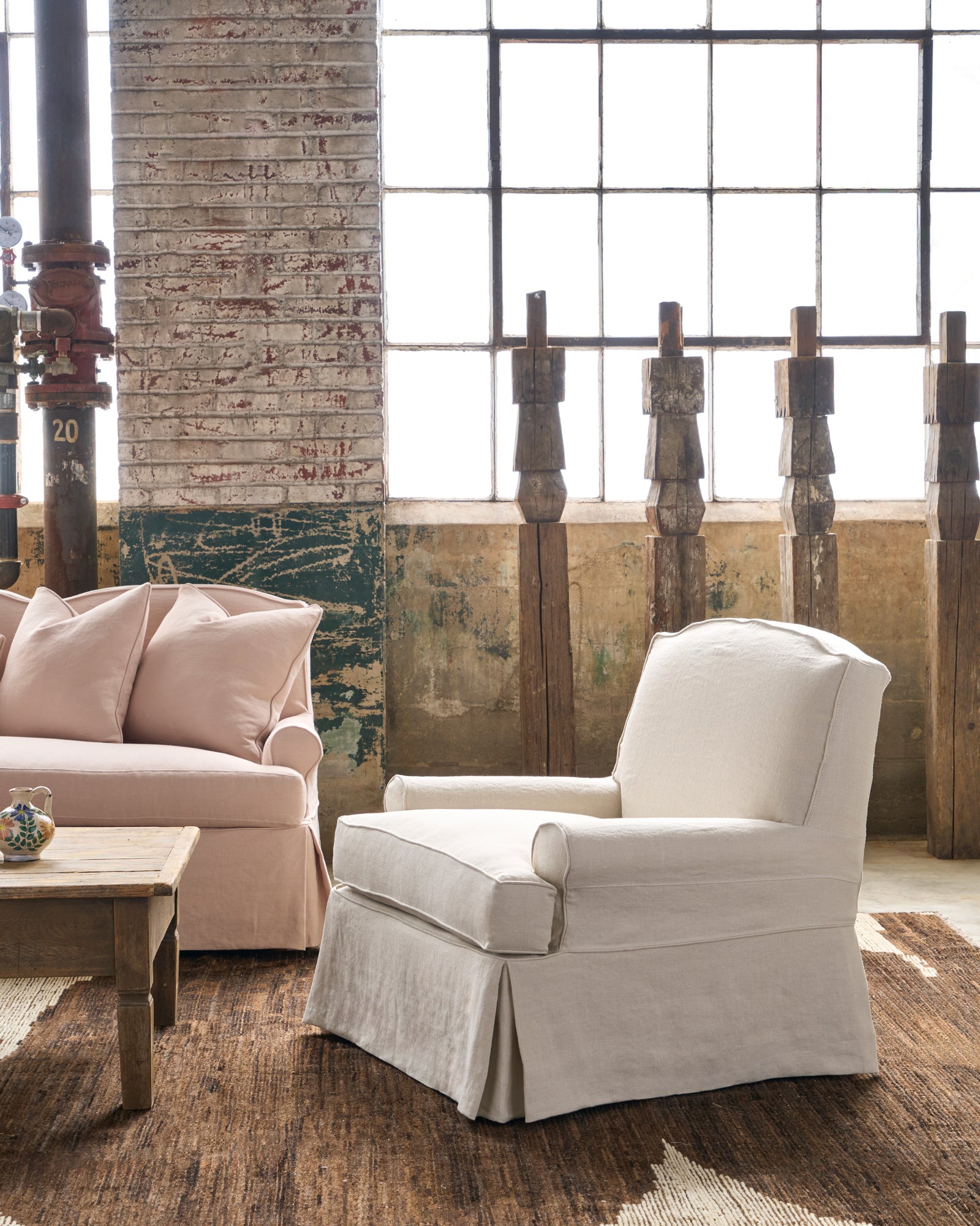  Chair by a pink sofa with wood sculptures behind. Photographed in Noah Bone. 