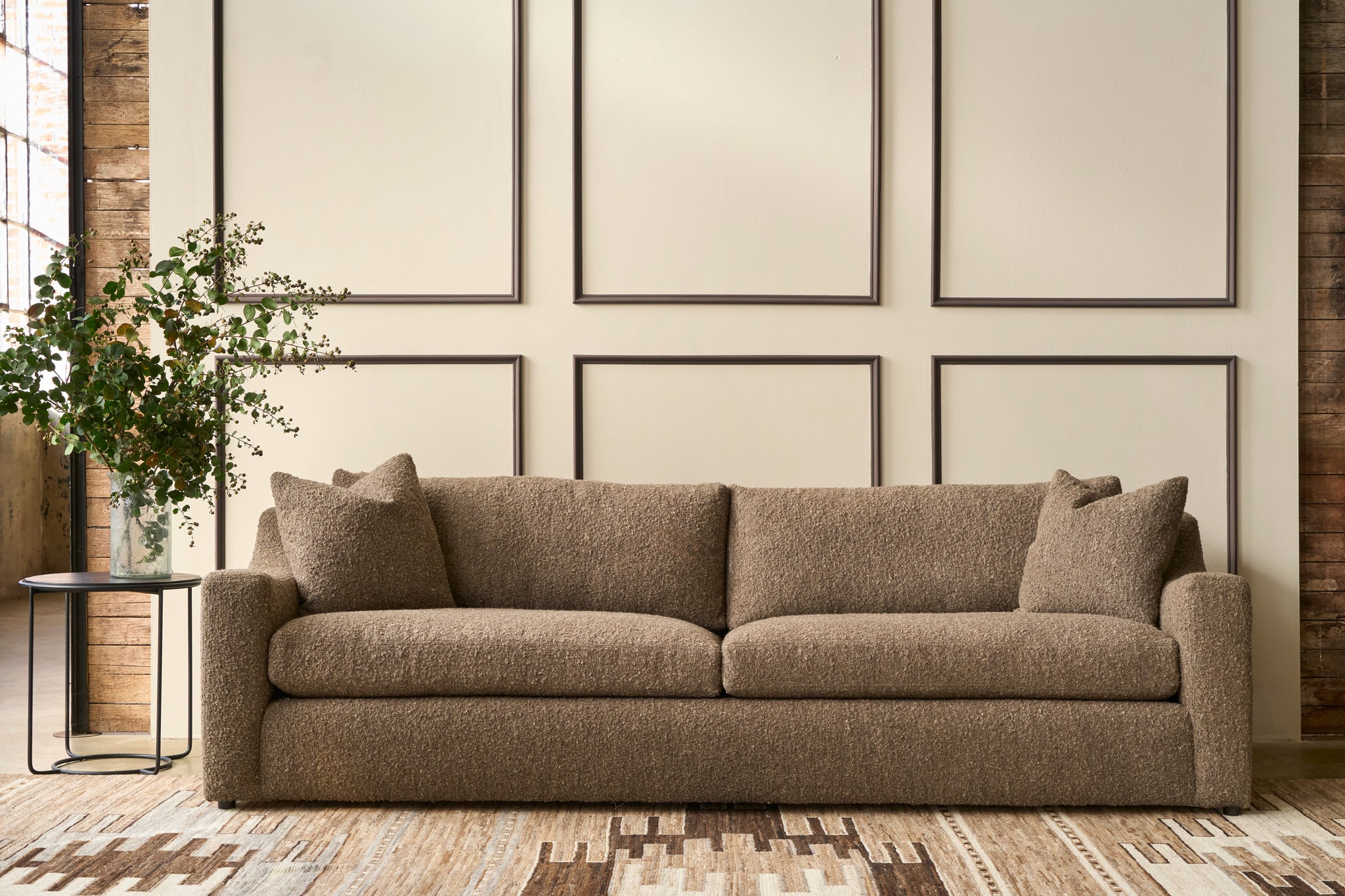  Brown sofa in a living room with framed artwork on the wall. Photographed in Knobby Coffee. 