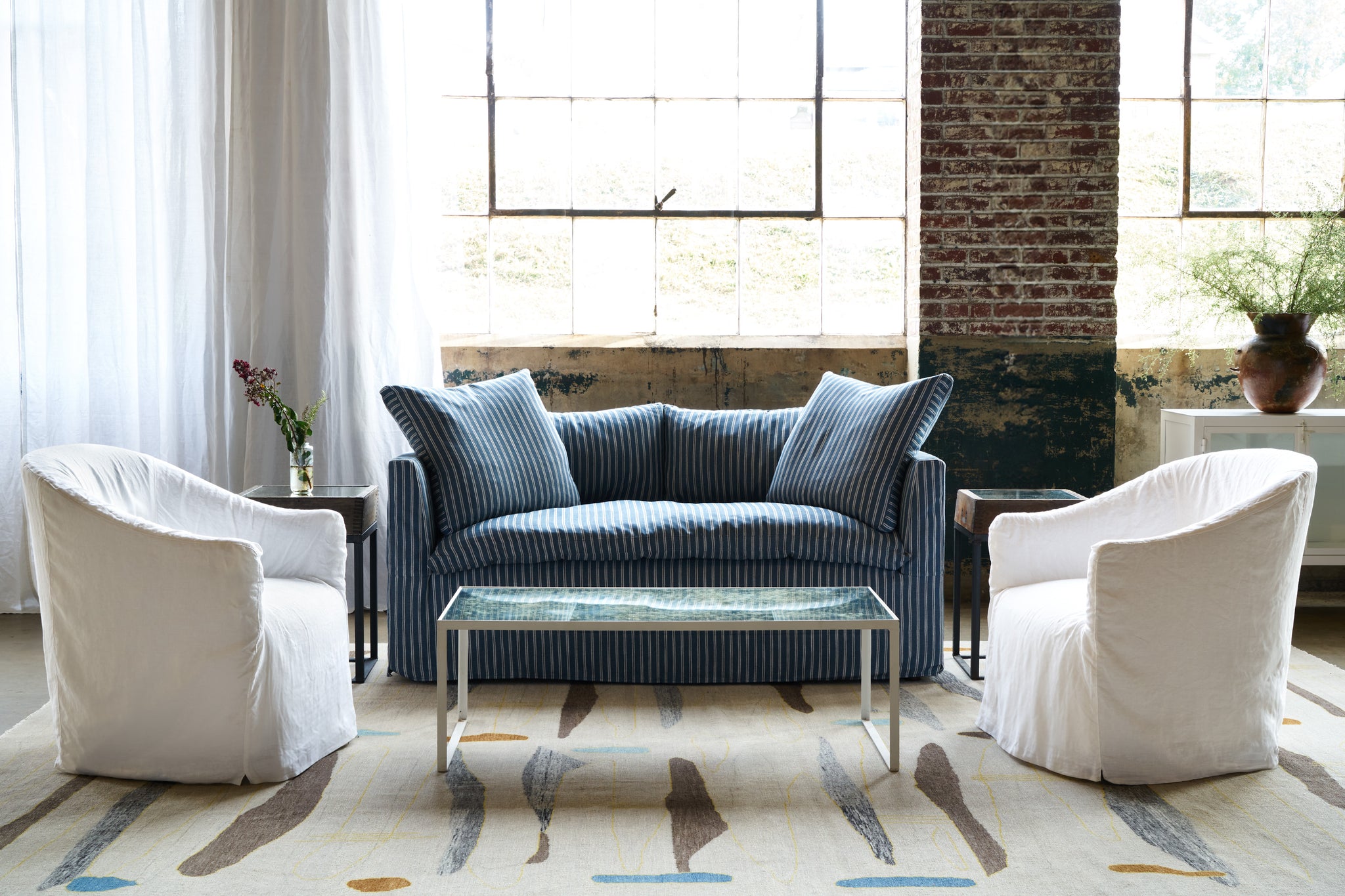 Loveseat blue with white stripes with a chair on each side. White coffee table with mirror. Photographed in Marine Blue. 