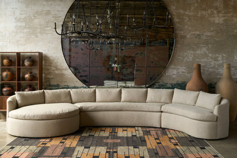 Beige sectional sofa in a room with a large mirror and decorative vases. Photographed in Bellamy Oatmeal.