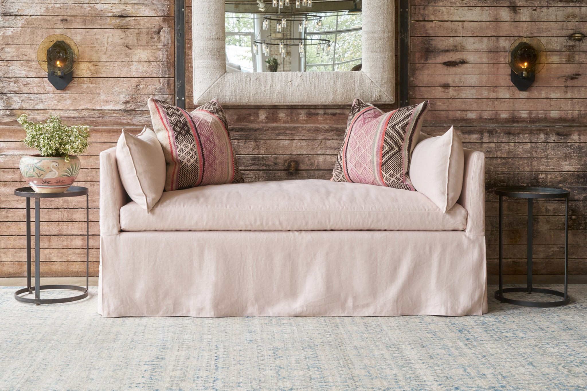  Pink linen daybed with 2 decorative pillows in front of a wood wall. Photographed in Brevard Rose. 