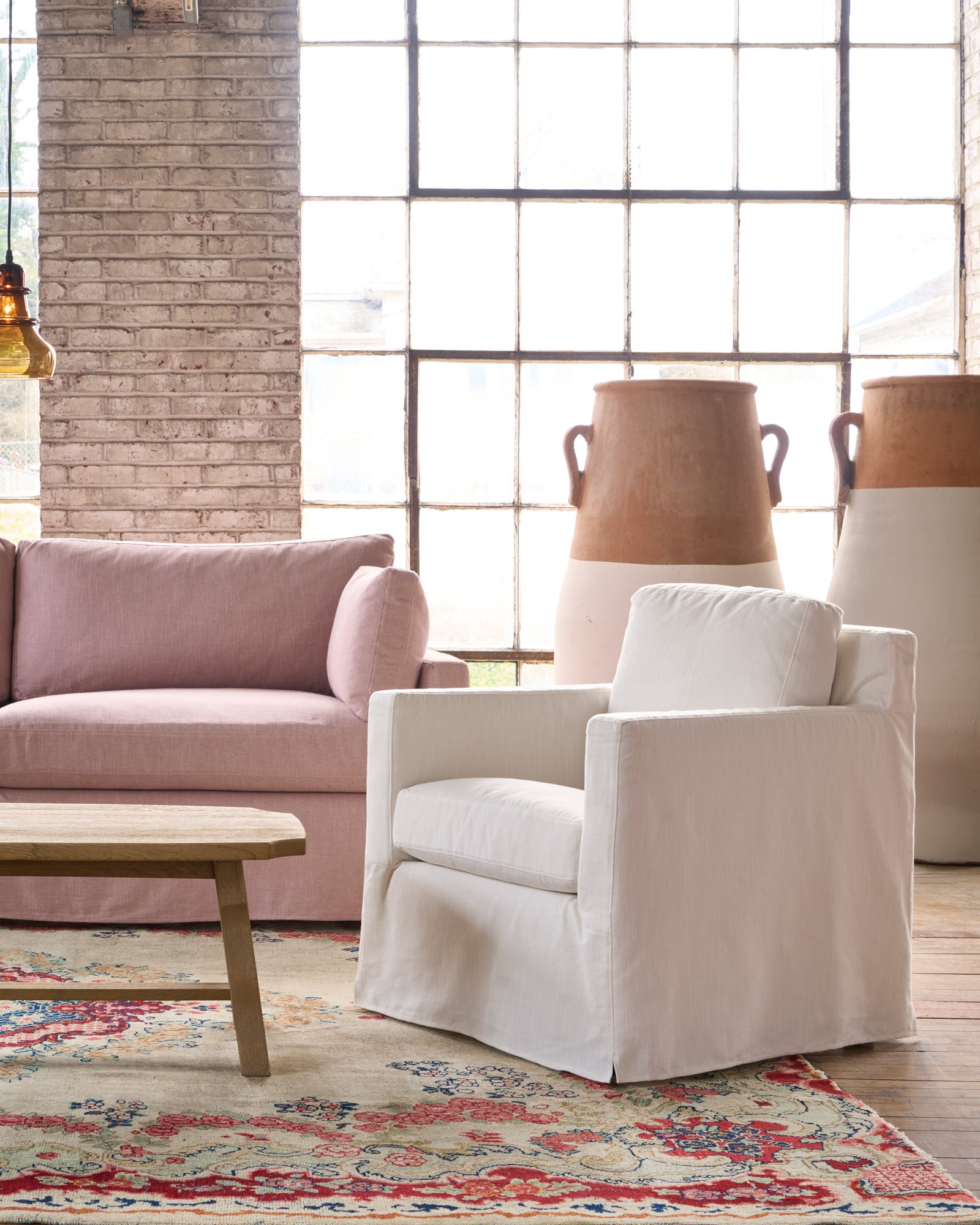  White slipcovered chair next to a ink sofa. Photographed in Elder Ivory. 