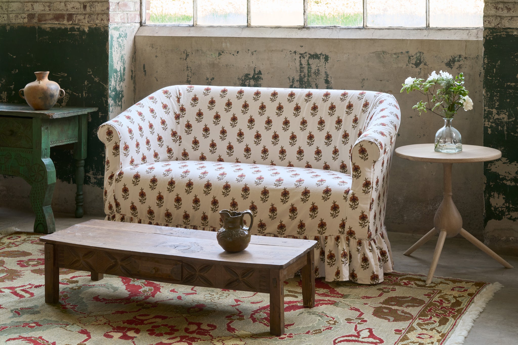  Patterned sofa in a room with a wooden coffee table and decorative items. Photographed in Solenia Ginger. 
