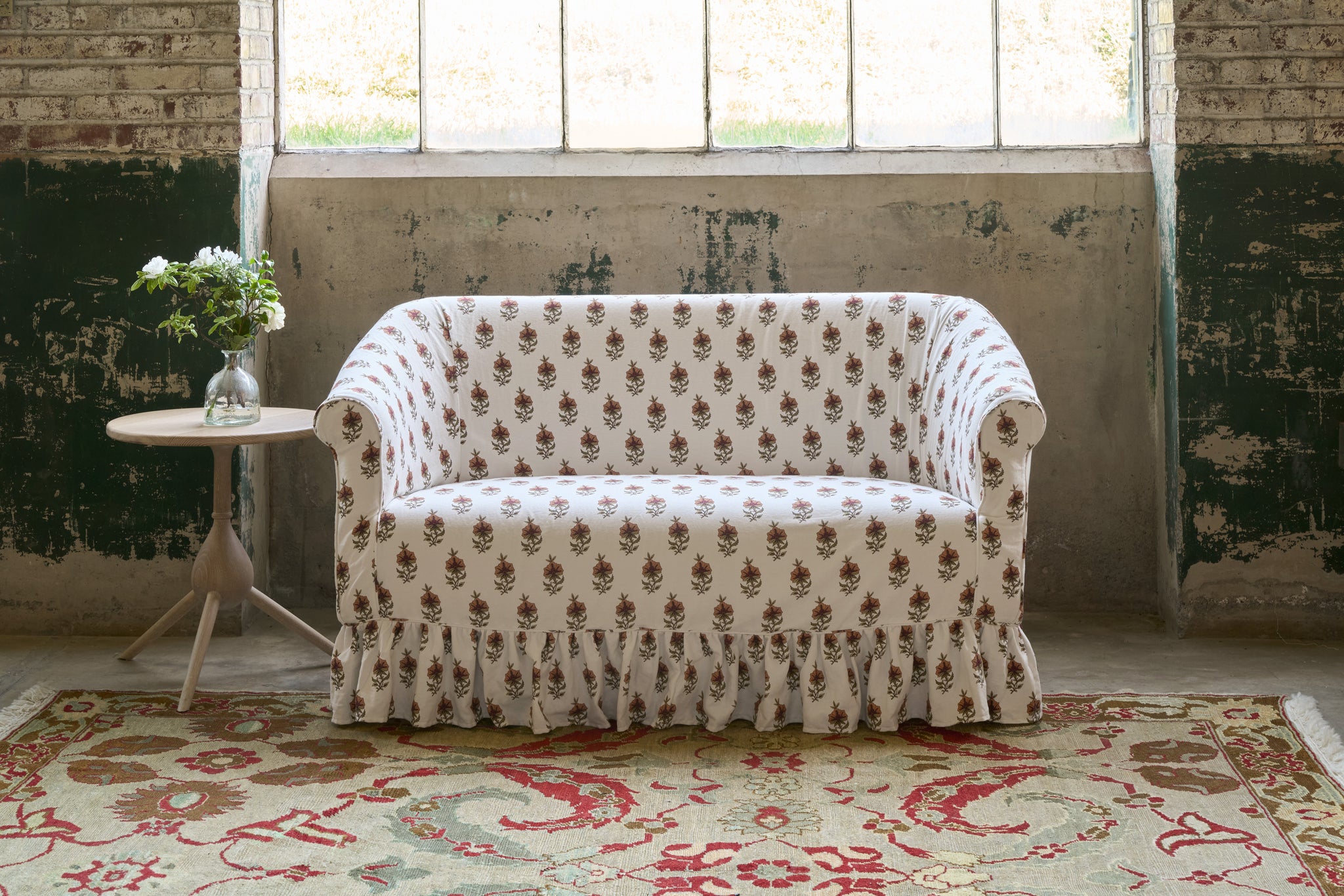  Patterned sofa in a room with large windows and a decorative rug. Photographed in Solenia Ginger. 