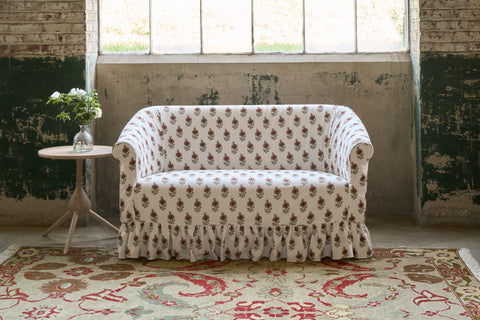 Patterned sofa in a room with large windows and a decorative rug. Photographed in Solenia Ginger.