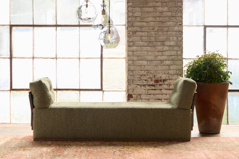 Green daybed in front of a window with a plant. Photographed in Knobby Moss.